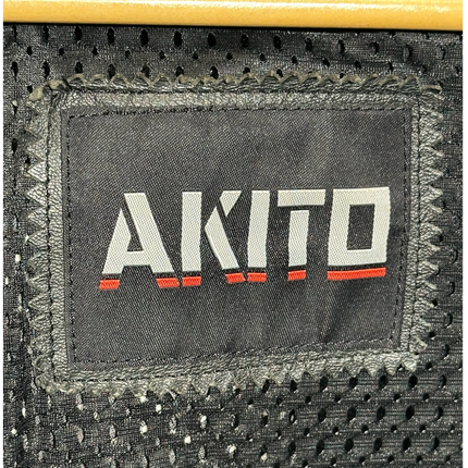 Close-up of the AKITO brand logo patch stitched onto the black breathable mesh interior lining of an OutOf10 jacket.