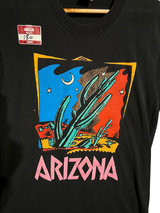 OutOf10 black cotton t-shirt featuring a vibrant retro Arizona desert graphic with a saguaro cactus and crescent moon.