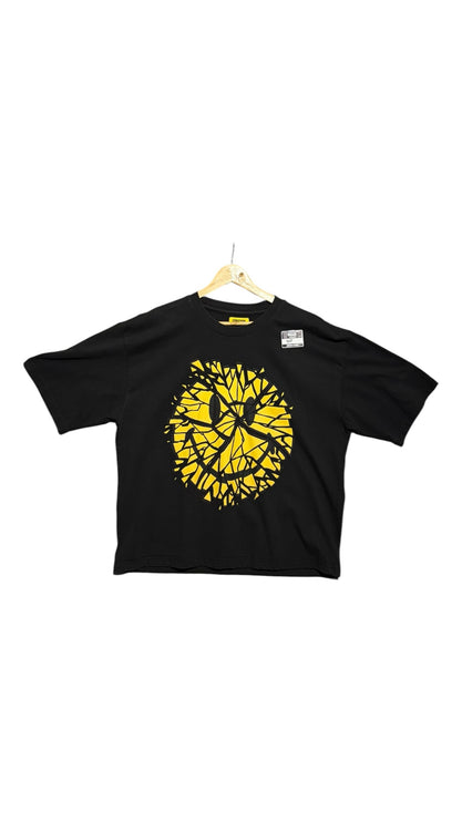OutOf10 black cotton t-shirt featuring a vibrant yellow shattered smiley face graphic print on the front.