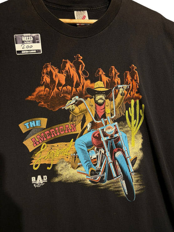 OutOf10 black cotton t-shirt featuring a vintage graphic of a cowboy riding a motorcycle with horses in the desert.