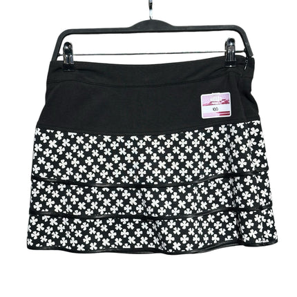 OutOf10 black and white floral print tiered athletic skirt with a wide waistband on a hanger