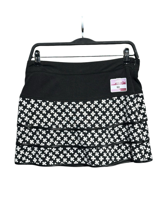 OutOf10 black and white floral print tiered athletic skirt with a wide waistband on a hanger