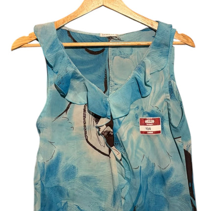 OutOf10 sleeveless blouse in blue with dark brown floral print and feminine ruffle trim neckline on a wooden hanger