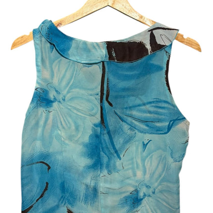 OutOf10 sleeveless blouse in blue with dark brown floral print and delicate ruffle trim on a wooden hanger