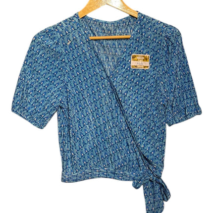 OutOf10 blue geometric print wrap blouse with short puffed sleeves, V-neckline, and side tie detail on a hanger.
