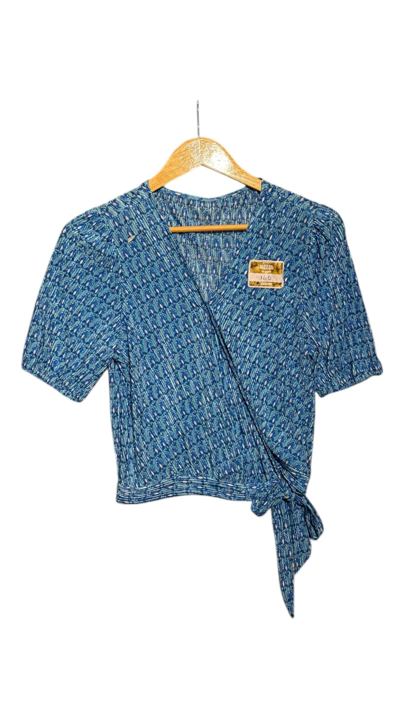 OutOf10 blue geometric print wrap blouse with short puffed sleeves, V-neckline, and side tie detail on a hanger.