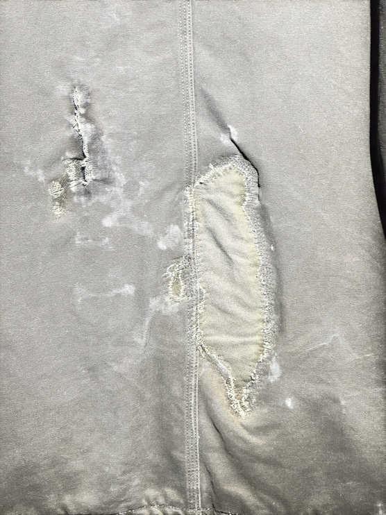 OutOf10 vintage Carhartt canvas work jacket featuring heavy distressed detailing and a reinforced fabric patch repair.