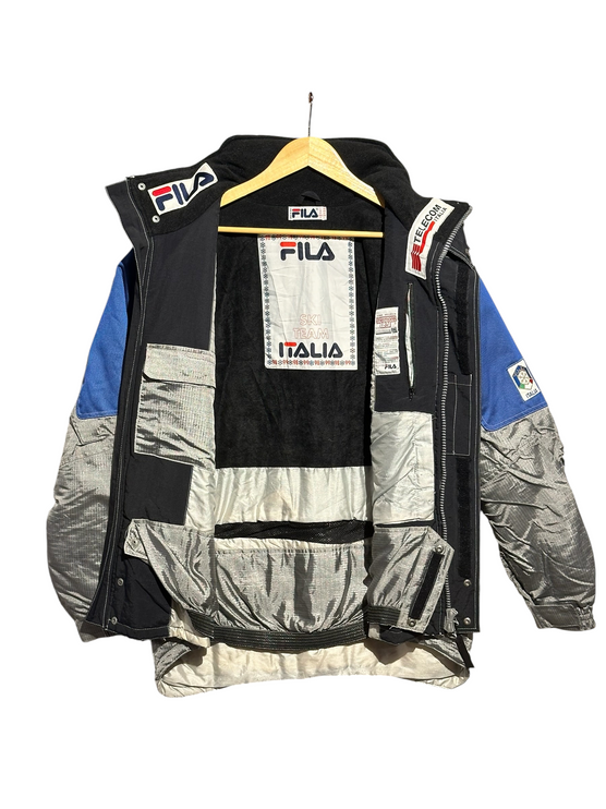 OutOf10 vintage FILA Ski Team Italia winter jacket featuring silver, blue, and black panels with interior branding.