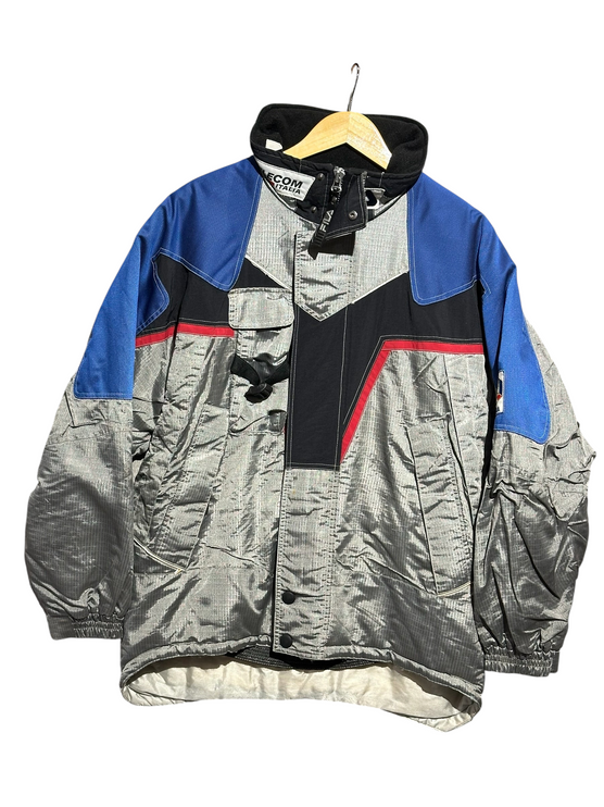 OutOf10 vintage FILA Ski Team Italia winter jacket in silver, royal blue, and black with red accents and high collar.