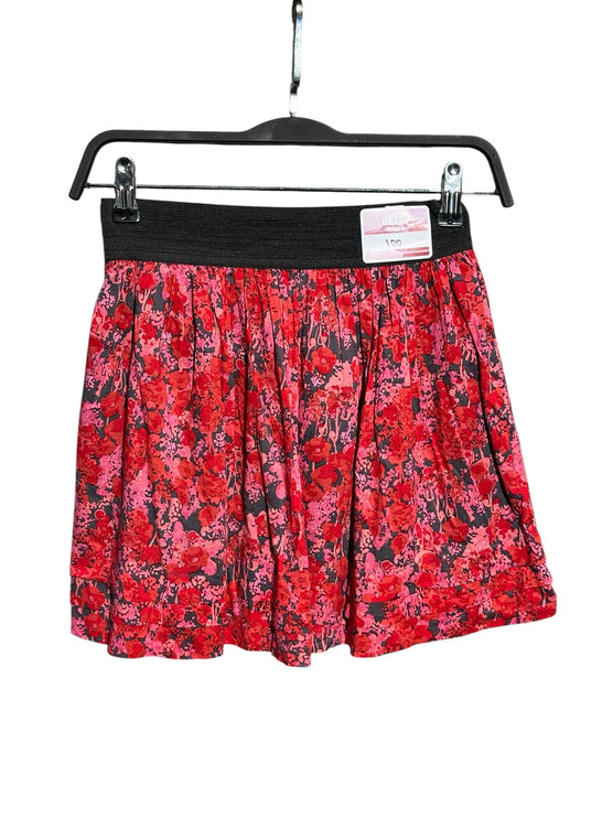 OutOf10 red and pink floral print mini skater skirt with a wide black elastic waistband hanging on a hanger