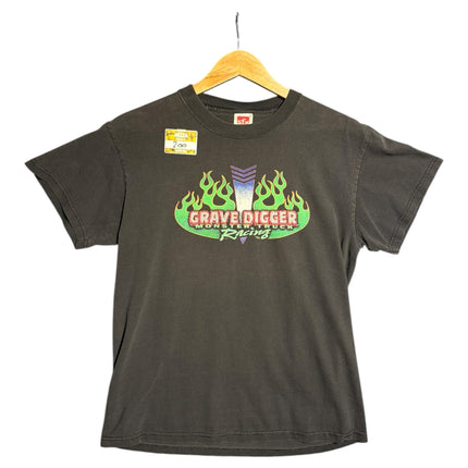 OutOf10 black cotton t-shirt featuring a Grave Digger monster truck graphic with vibrant green flames and logo.