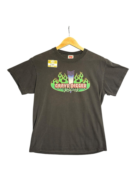 OutOf10 black cotton t-shirt featuring a Grave Digger monster truck graphic with vibrant green flames and logo.