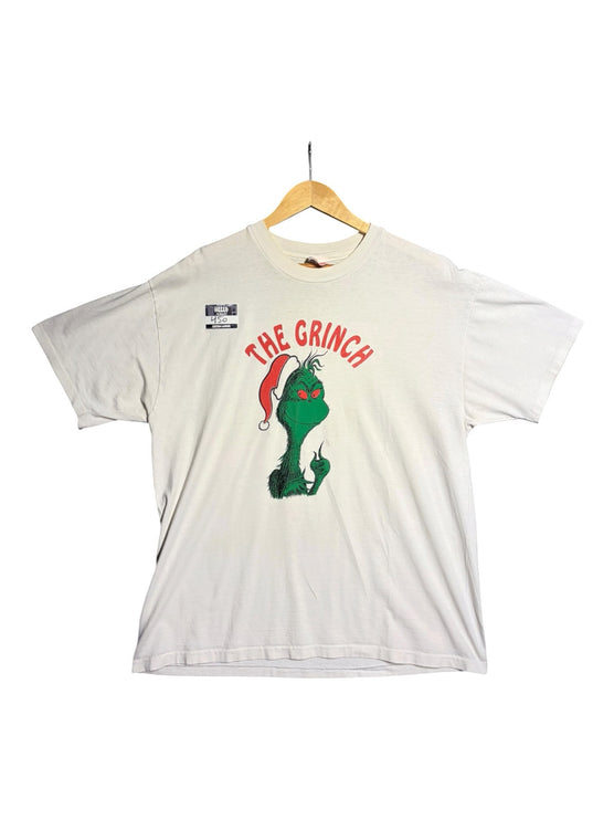 OutOf10 off-white cotton t-shirt featuring a vibrant Grinch graphic print with a Santa hat on a wooden hanger