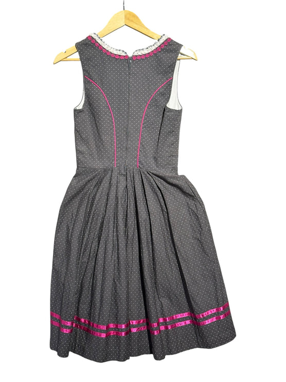 Back view of OutOf10 Hammerschmid charcoal grey dirndl dress with white polka dots, pink piping, and ribbon hem detail.