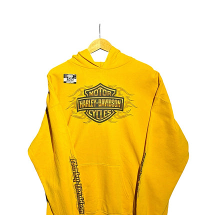 OutOf10 yellow Harley-Davidson pullover hoodie with front flame logo and sleeve text on a wooden hanger
