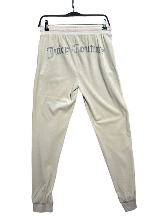 OutOf10 Juicy Couture cream velour joggers with rhinestone branding on the back, hanging on a black hanger.