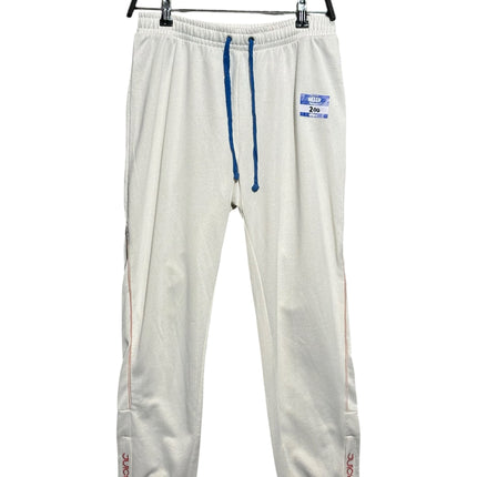 OutOf10 Juicy Couture Black Label off-white jogger pants with blue drawstring and Hello name tag detail on the hip.