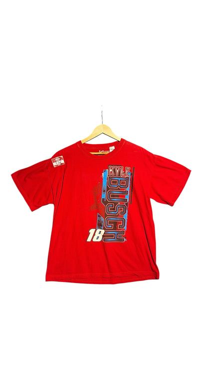 OutOf10 red Kyle Busch NASCAR graphic t-shirt with number 18 and Joe Gibbs Racing branding on a wooden hanger.