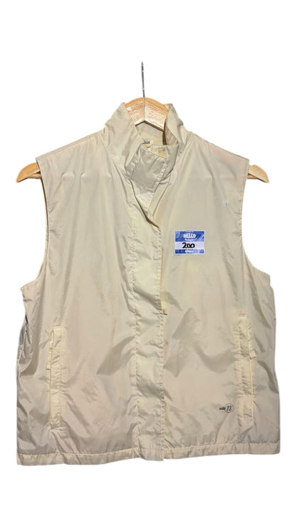 OutOf10 Nike cream sleeveless zip-up performance vest with high neck and side pockets on a wooden hanger