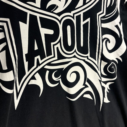 OutOf10 black cotton t-shirt featuring a large white tribal-inspired Tapout logo graphic print on the chest