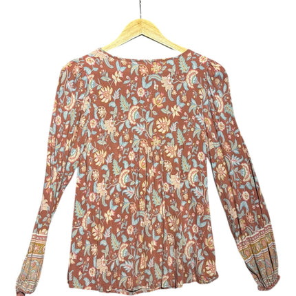 OutOf10 bohemian long-sleeve blouse in terracotta with blue, cream, and sage green floral print on a wooden hanger
