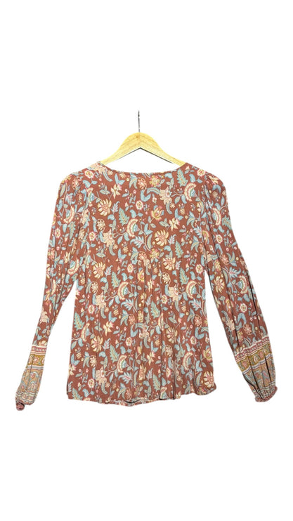 OutOf10 bohemian long-sleeve blouse in terracotta with blue, cream, and sage green floral print on a wooden hanger