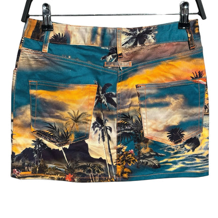 OutOf10 denim mini skirt featuring a vibrant tropical sunset landscape print with palm trees in teal and orange tones.