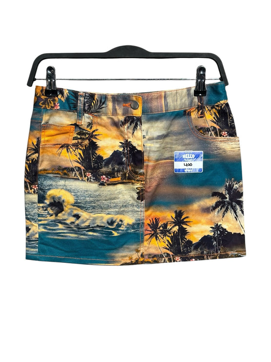 OutOf10 denim mini skirt featuring a vibrant tropical sunset landscape print with palm trees and ocean waves.
