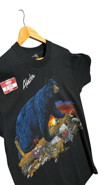 OutOf10 black cotton t-shirt featuring a vintage Alaska bear graphic with a sunset landscape on a wooden hanger