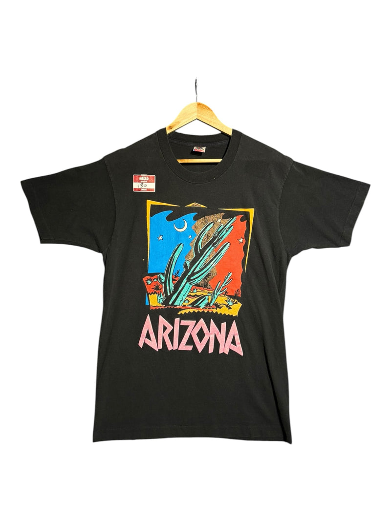 OutOf10 black cotton t-shirt featuring a vintage Arizona desert graphic print with saguaro cacti and pink lettering.