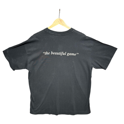 OutOf10 vintage black cotton t-shirt with the beautiful game text printed on the back, hanging on a wooden hanger.