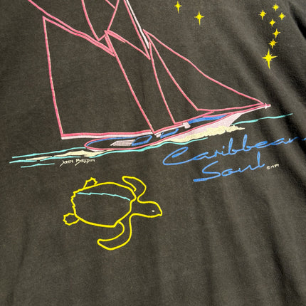 OutOf10 black cotton t-shirt featuring a vintage Caribbean Soul graphic with a sailboat, sea turtle, and yellow stars.