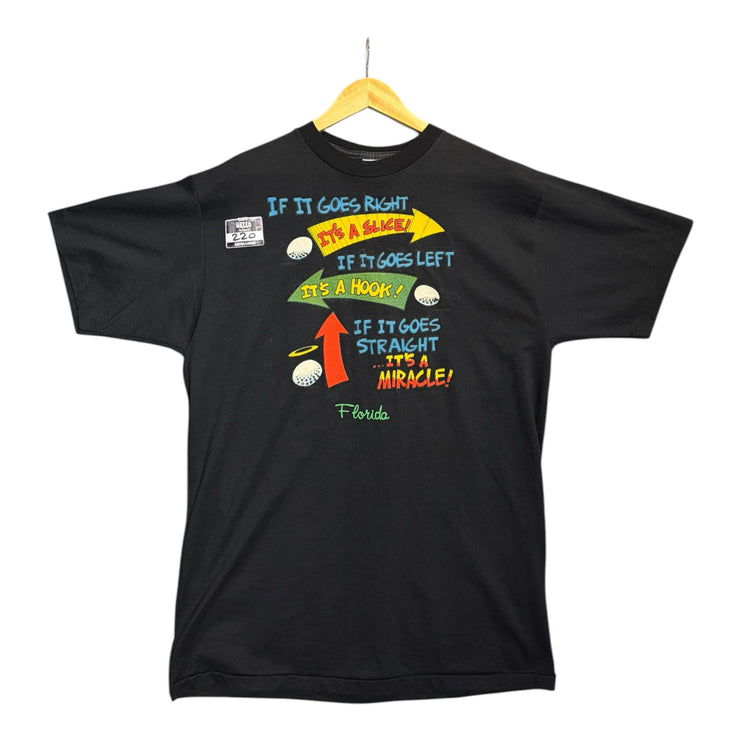 OutOf10 black cotton crewneck t-shirt featuring a vintage golf humor graphic print about golf swings on a hanger.