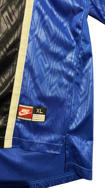 OutOf10 vintage Nike athletic jersey in royal blue and black with a geometric jacquard pattern and hem patch detail.