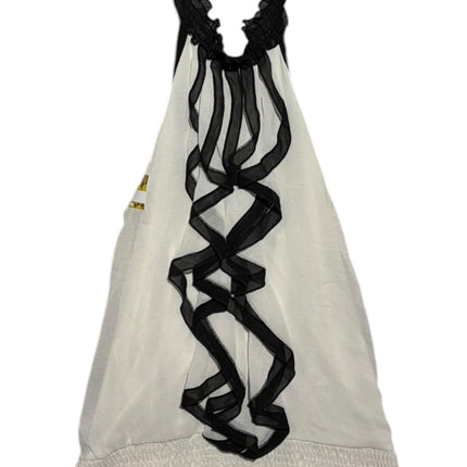 OutOf10 white sleeveless halter neck blouse with black ruffled trim and a shirred elastic hem on a wooden hanger.