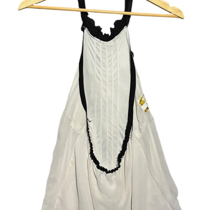 OutOf10 white sleeveless halter neck blouse with black ruffled trim and a shirred elastic hem on a wooden hanger