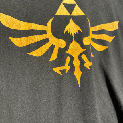 OutOf10 black cotton crewneck t-shirt featuring a distressed gold Legend of Zelda Hylian Crest and Triforce graphic.